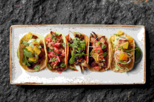 5 tacos on a plate at Merkado, a San Francisco restaurant